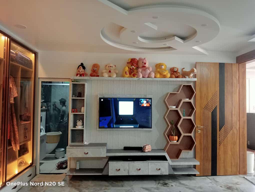 Residential living room with custom TV unit and false ceiling